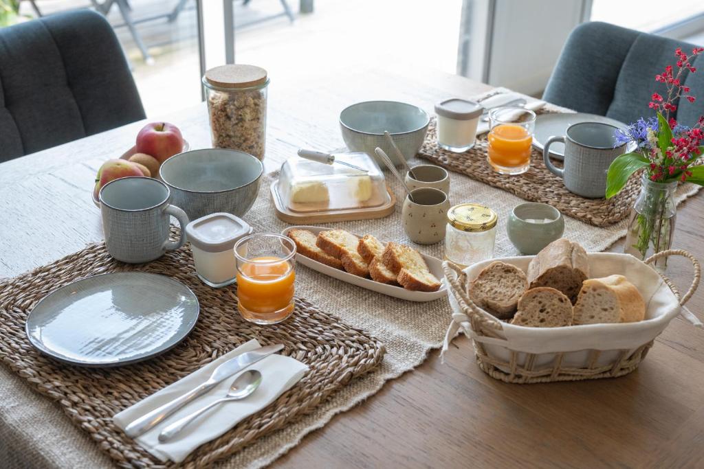 Petit-déjeuner servi à table avec pain, jus et boissons chaudes